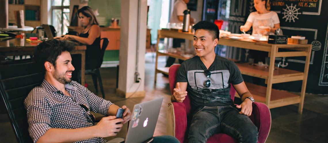 photograph of men having conversation seating on chair